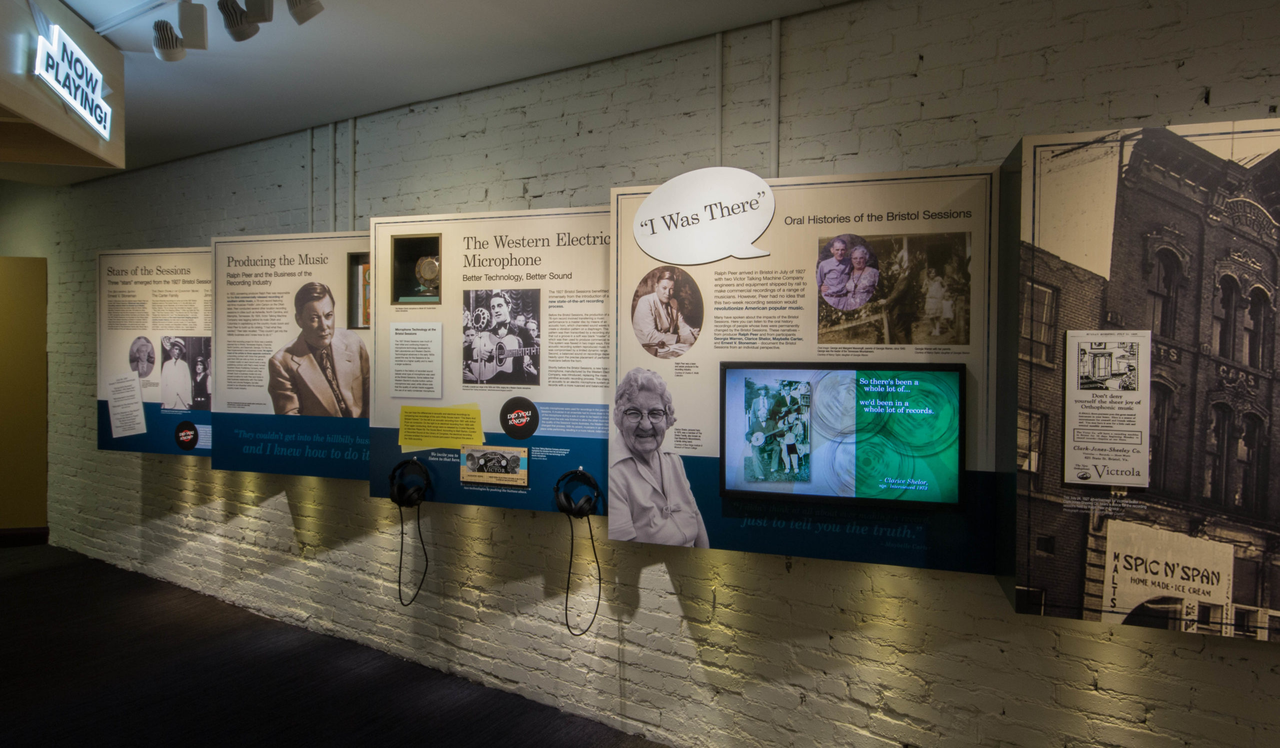 A view of the five sawtooth panels in the museum, each focusing on a different element of the 1927 Bristol Sessions. From left to right, we see "Stars of the Sessions," "Producing the Music" (Ralph Peer), "The Western Electric Microphone," "I Was There," and the brief history of the Sessions in Bristol.