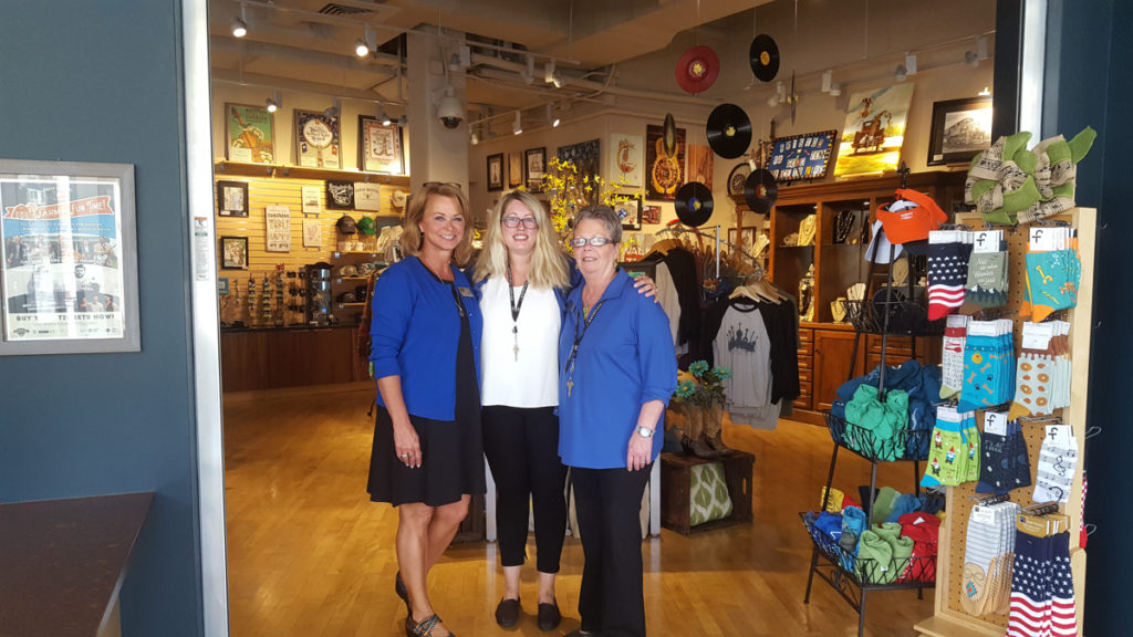 A photograph of the three frontline staff associates standing in The Museum Store.