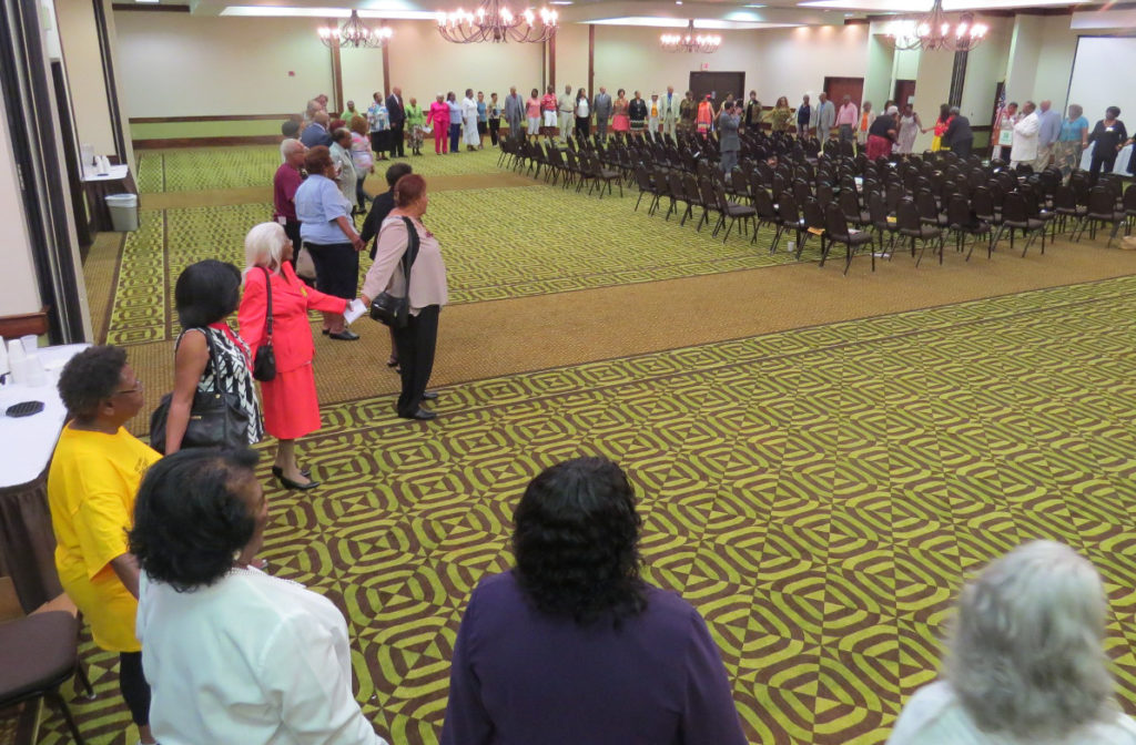 A line of alumni hold hands as they gather together in prayer at the Great Golden Gathering.