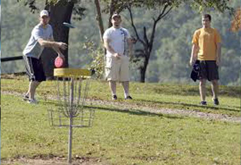 Three men playing Disc Golf at Steele Creek Park.

