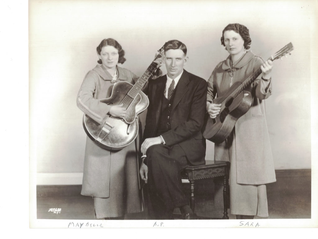 A picture of The Carter Family -- Maybelle holding her guitar, A. P., and Sarah holding her guitar