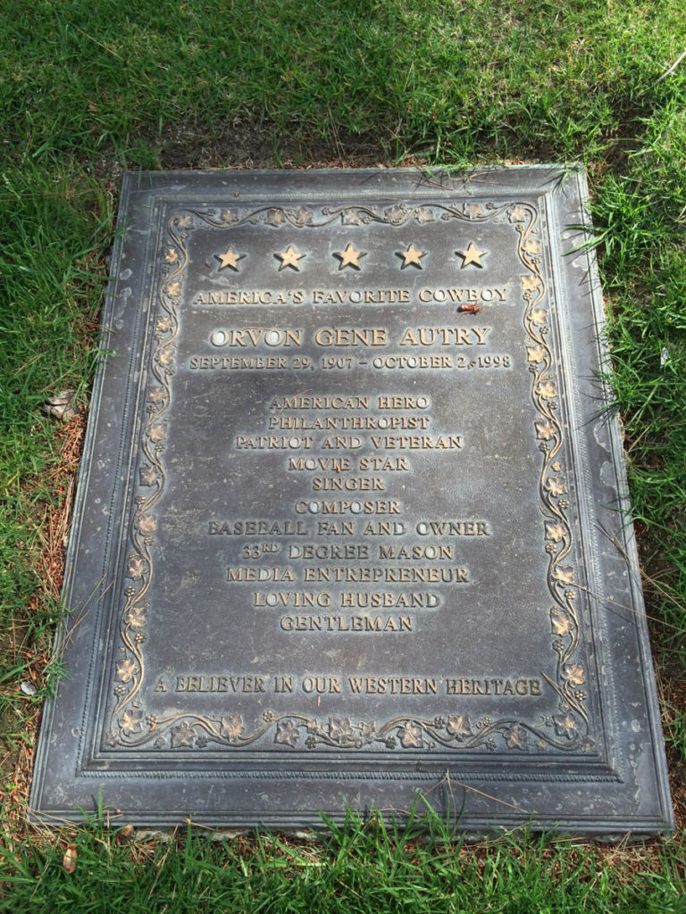 Grave of Gene Autry with a large memorial in the ground with his name and numerous accolades from American hero to Gentleman.