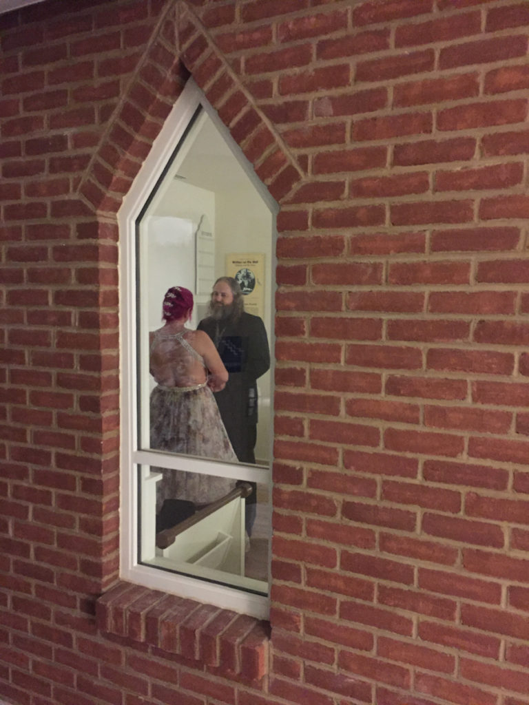 The bride and groom can be seen facing each other during their vows through the small chapel window in the museum exhibits.