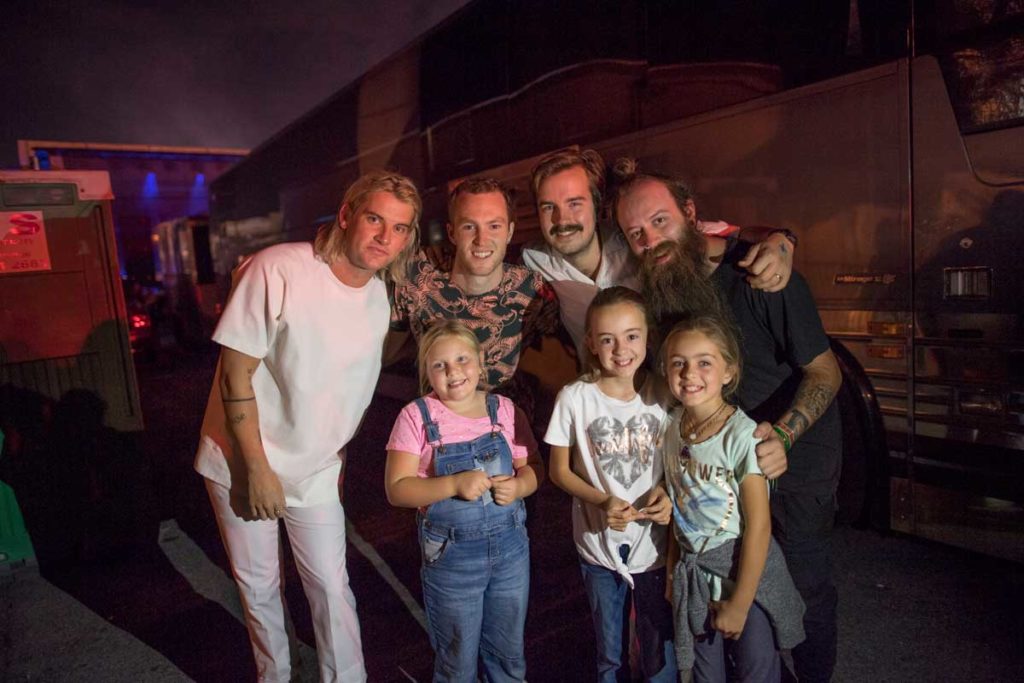 The Band Judah & The Lion posing for pictures with Leah's granddaughter Mary Nell and two friends backstage at the festival