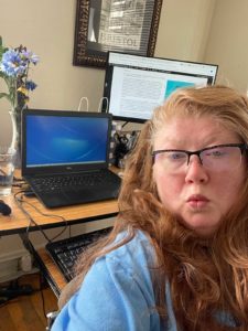 Selfie photo of blogger sitting at home office computer.