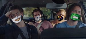 Four people in a car wearing seatbelts with COVI-19 masks photoshopped to their faces.