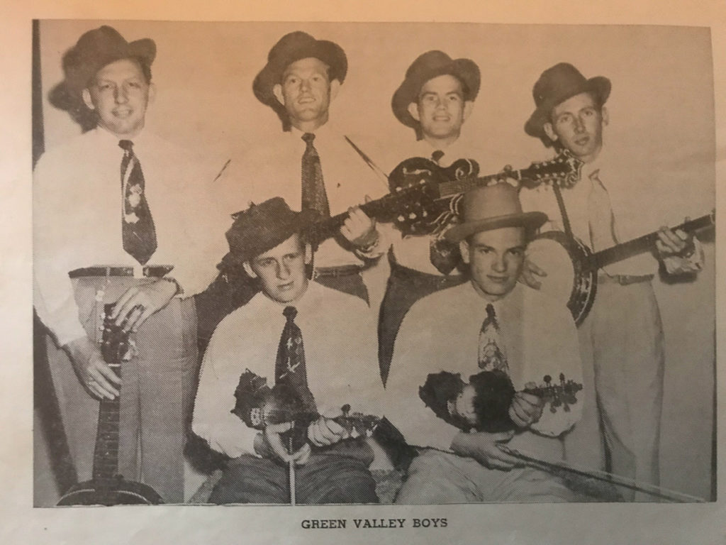 A black-and-white image of six male musicians, all wearing white shirts, ties, and hats, and holding their instruments.