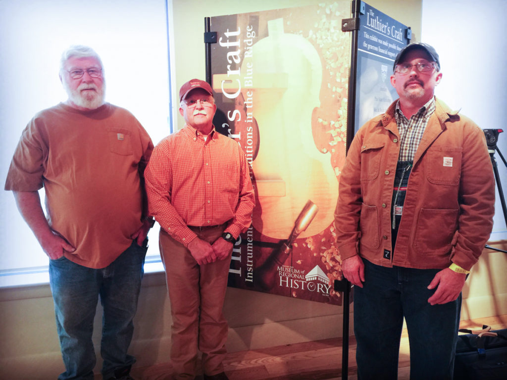 Chuck Tipton, Randal Eller, and Kevin Fore standing in front of the opening panel to The Luthier's Craft exhibit.