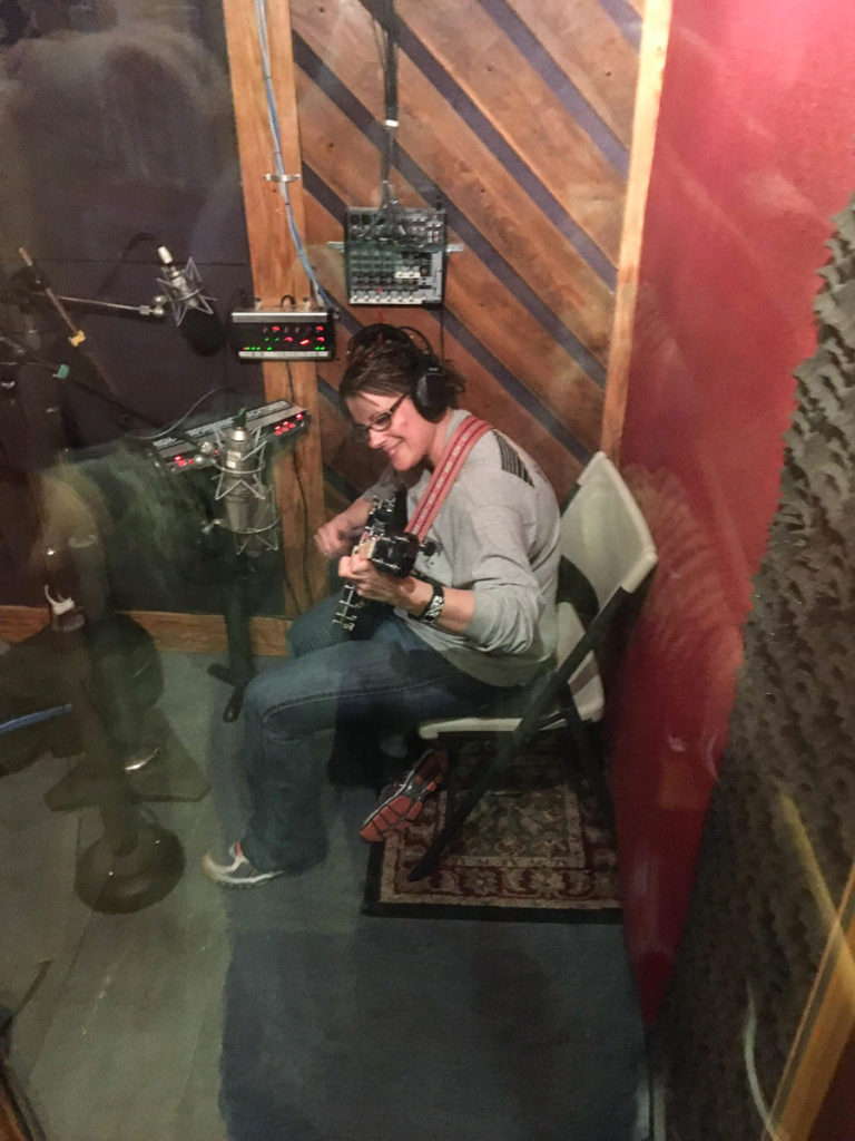 Trish Fore playing banjo in the recording studio.