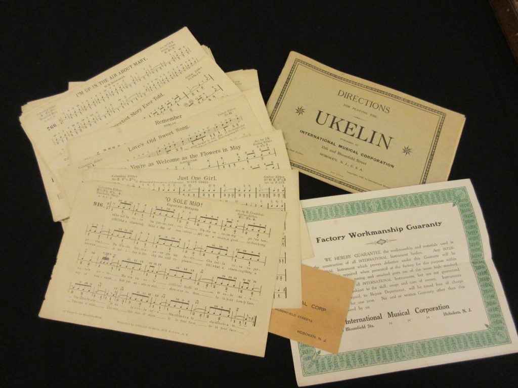 Several pages of sheet music for the ukelin, along with directions on how to use it and the Factory Workmanship Guaranty certificate.