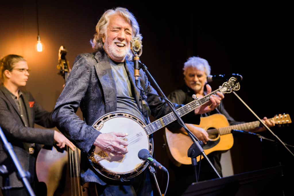 John McEuen performing at November's Farm and Fun Time show; seen here playing his banjo.
