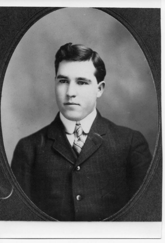 Black-and-white portrait of W. E. Myer as a young man -- dark hair, dark suit, high collar and striped tie.