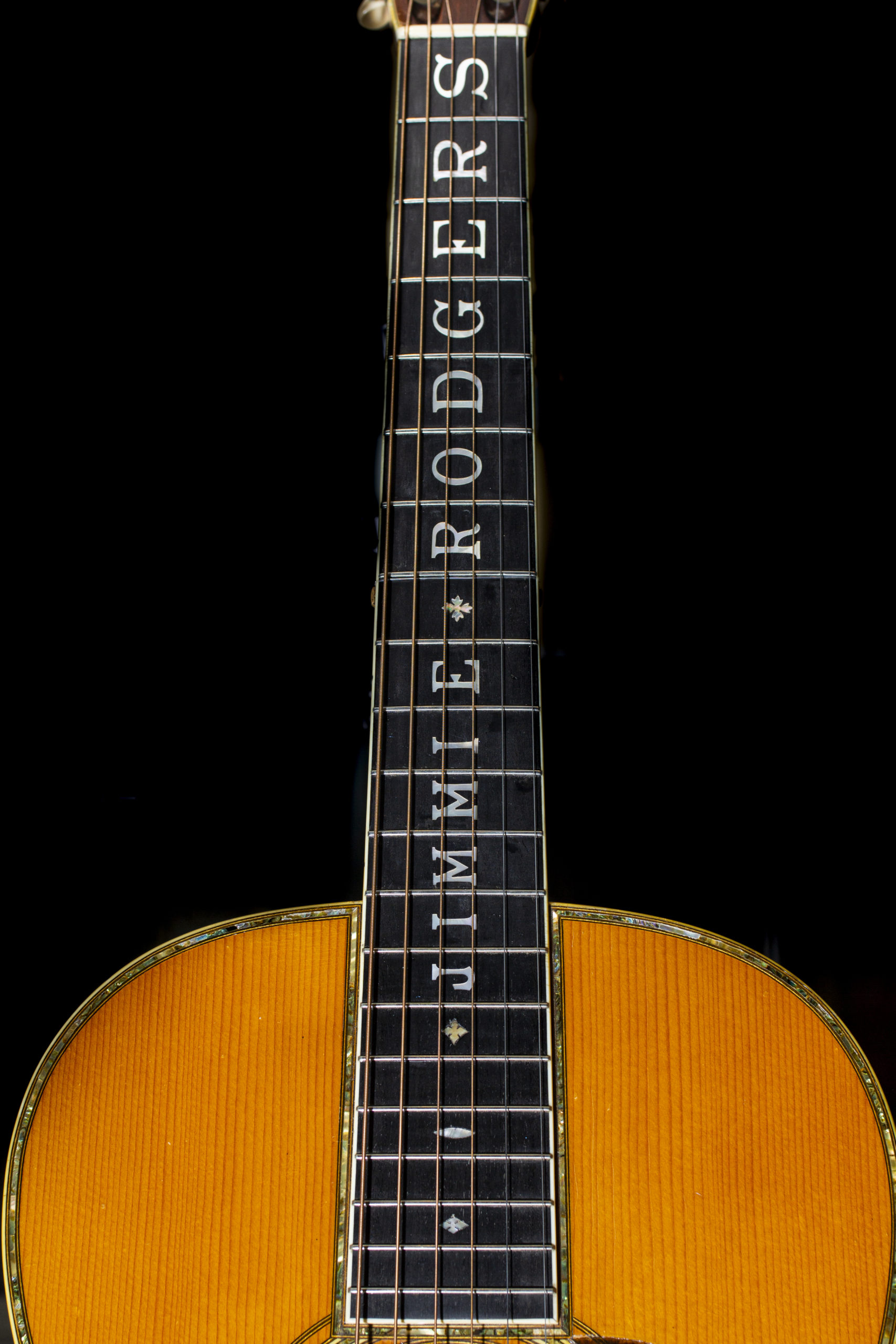 The neck of Jimmie Rodgers "Blue Yodel" guitar depicting the artist's name in pearl inlay across the bridge
