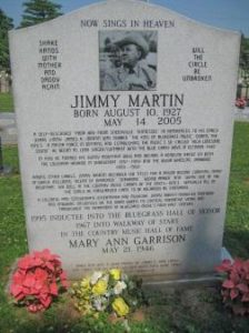 Jimmy Martin's tombstone: a large rectangular marble stone with curved top. It bears a large amount of text extolling Martin's life events and career achievements, along with an etched image of Martin at the top.