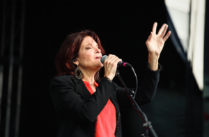 Photo of Rosanne Cash singing into a microphone
