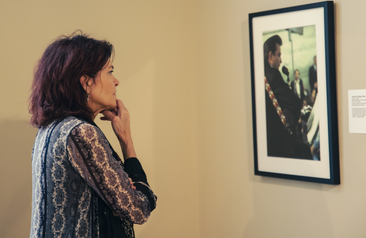 Rosanne Cash lingering at a photo of her late father, Johnny Cash