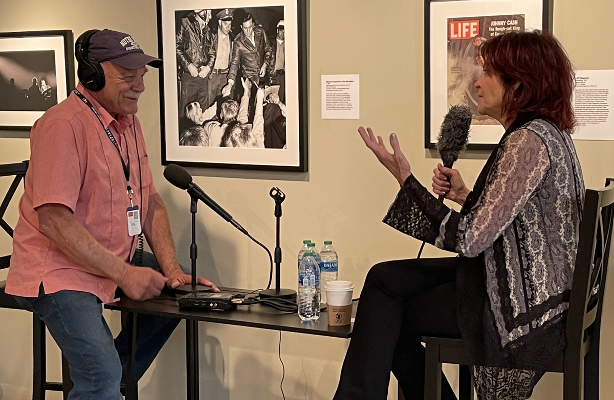 NPR's Tom Wilmer, wearing headphones, conducting an interview with Rosanne Cash