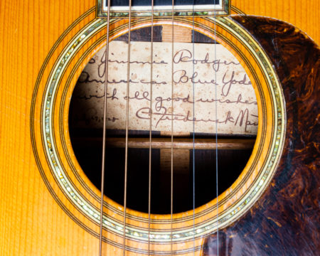 Close up of the sound hole of the guitar, showing a handwritten label inside to Jimmie Rodgers from C. F. Martin where he calls Jimmie "America's Blue Yodeler."