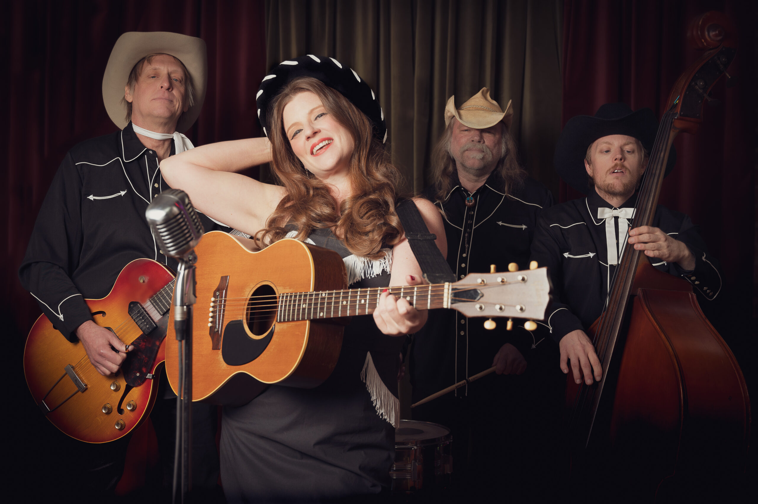 A photo of the band Kelley and The Cowboys holding instruments and wearing cowboy hats.