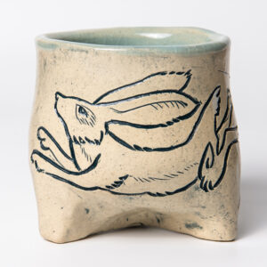 Photo of a wine cup made from pottery. It features a rabbit design etched into the cup.