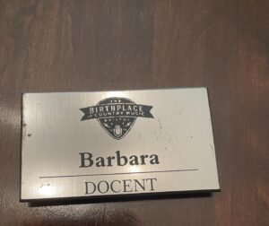 A silver nametag with the Birthplace of Country Music Logo, reading "Barbara- Docent."