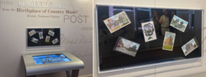 image of postcard kiosk at the museum. A black shadow box with various postcards is hanging on the wall above the kiosk.