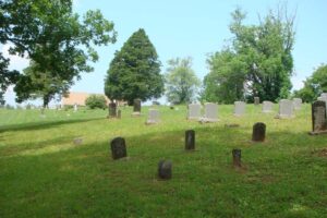 grassy hill with numerous old tombstones.