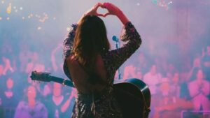 A photo of Molly Tuttle holding up a love sign at Bristol Rhythm & Roots Reunion 2025.